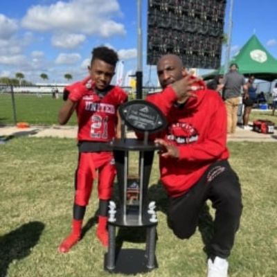 Jabril Talib and Aqib Talib posing next to a trophy.